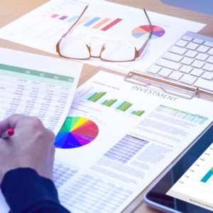 Analyzing business reports and charts on a desk with tablet.