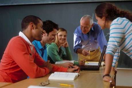 Educators and adult learners receiving support in a classroom