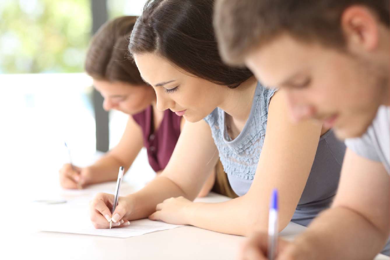 Students focused on writing during an exam or class.