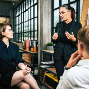 Businesswoman leading a discussion with colleagues in a modern office.