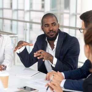Black millennial boss leading corporate team during briefing in boardroom