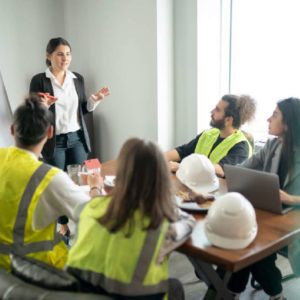 Construction team meeting with a female leader presenting.