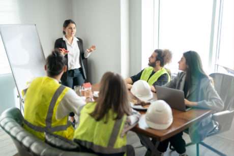 Construction team meeting with a female leader presenting.