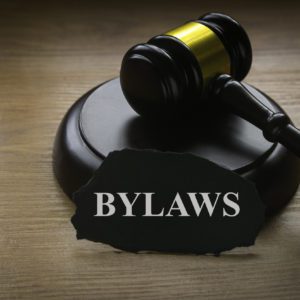 Bylaws phrase with gavel on wooden background. Business and law concept