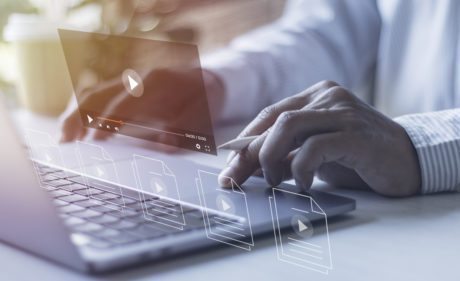 Businessman hands using laptops for streaming online on virtual screens, watching videos on the internet.