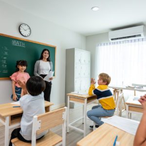 Group of student learn with teacher in classroom at elementary school.