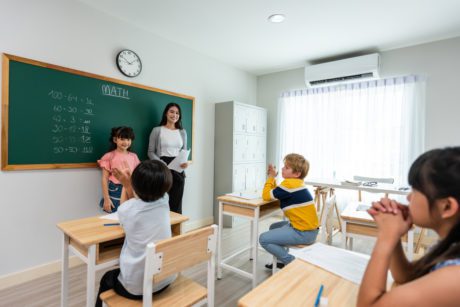 Group of student learn with teacher in classroom at elementary school.
