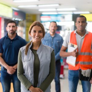 Happy group of Latin American workers working at a hardware store and looking at the camera smiling