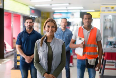 Happy group of Latin American workers working at a hardware store and looking at the camera smiling