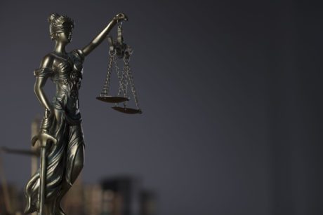 Themis , scale and legal books. Gray background.