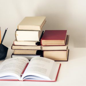 Stack of old books, textbook and pencils in office background for education concept