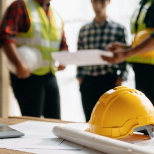 Engineer teams meeting working together wear worker helmets hardhat on construction site in modern city.Asian industry professional team in sun light