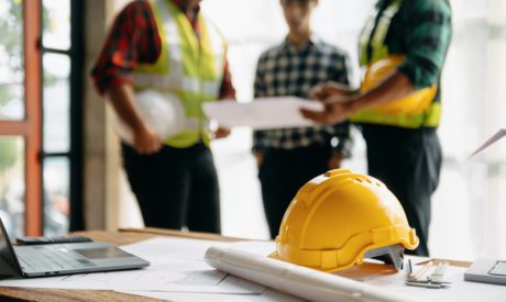 Engineer teams meeting working together wear worker helmets hardhat on construction site in modern city.Asian industry professional team in sun light